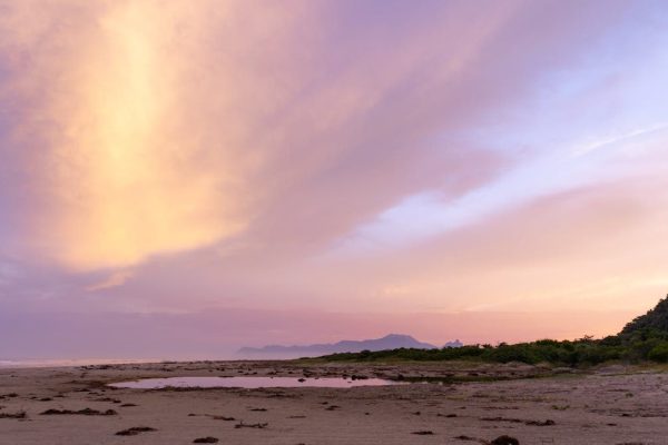 Stunning sunset view at Barra do Una beach, showcasing vibrant skies and serene coastline.